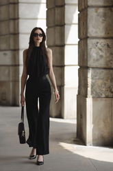 a lady in an off the shoulder black top and a pair of black pants